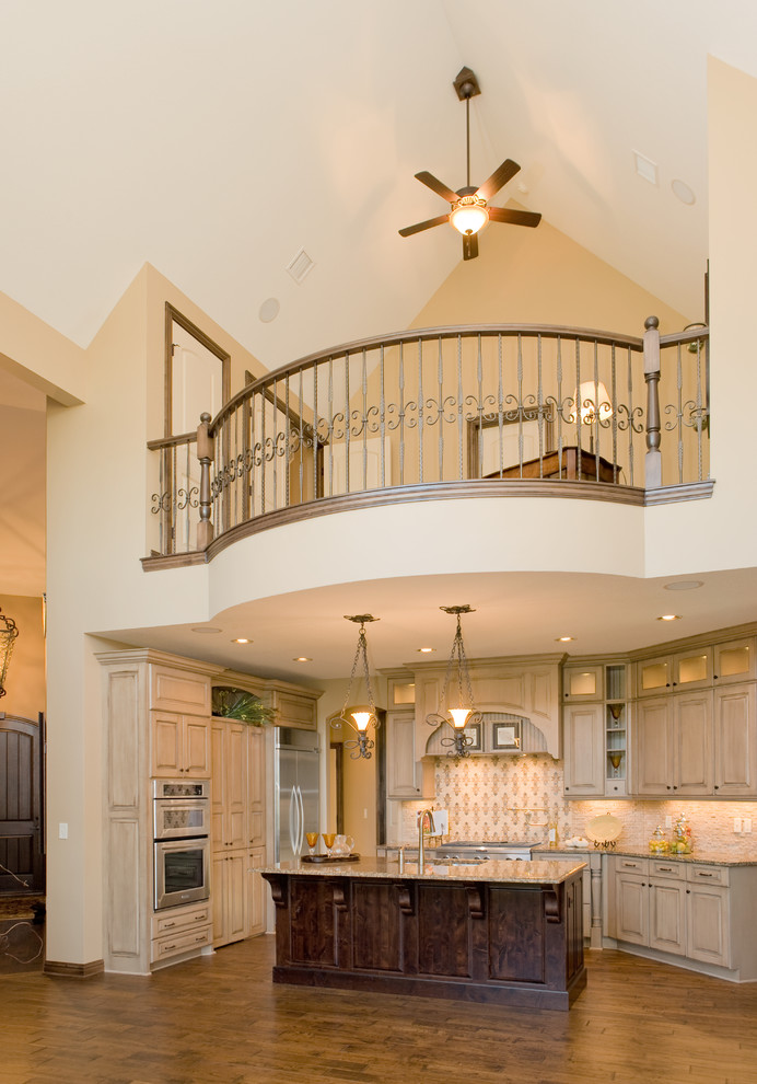 Design ideas for a traditional u-shaped open plan kitchen in Wichita with raised-panel cabinets, beige cabinets, beige splashback and stainless steel appliances.