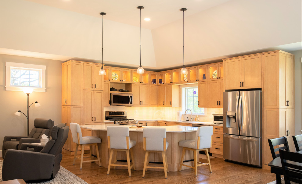 Modern inredning av ett mellanstort vit vitt kök, med en undermonterad diskho, skåp i shakerstil, skåp i ljust trä, bänkskiva i kvarts, gult stänkskydd, stänkskydd i keramik, rostfria vitvaror, mellanmörkt trägolv, en köksö och brunt golv