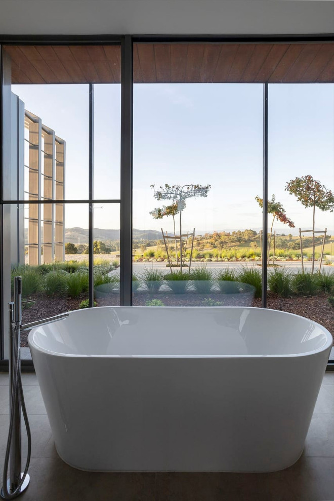 Großes Modernes Badezimmer En Suite mit weißen Schränken, freistehender Badewanne, weißer Wandfarbe, hellem Holzboden, Mineralwerkstoff-Waschtisch, braunem Boden, Einzelwaschbecken und eingebautem Waschtisch in Melbourne
