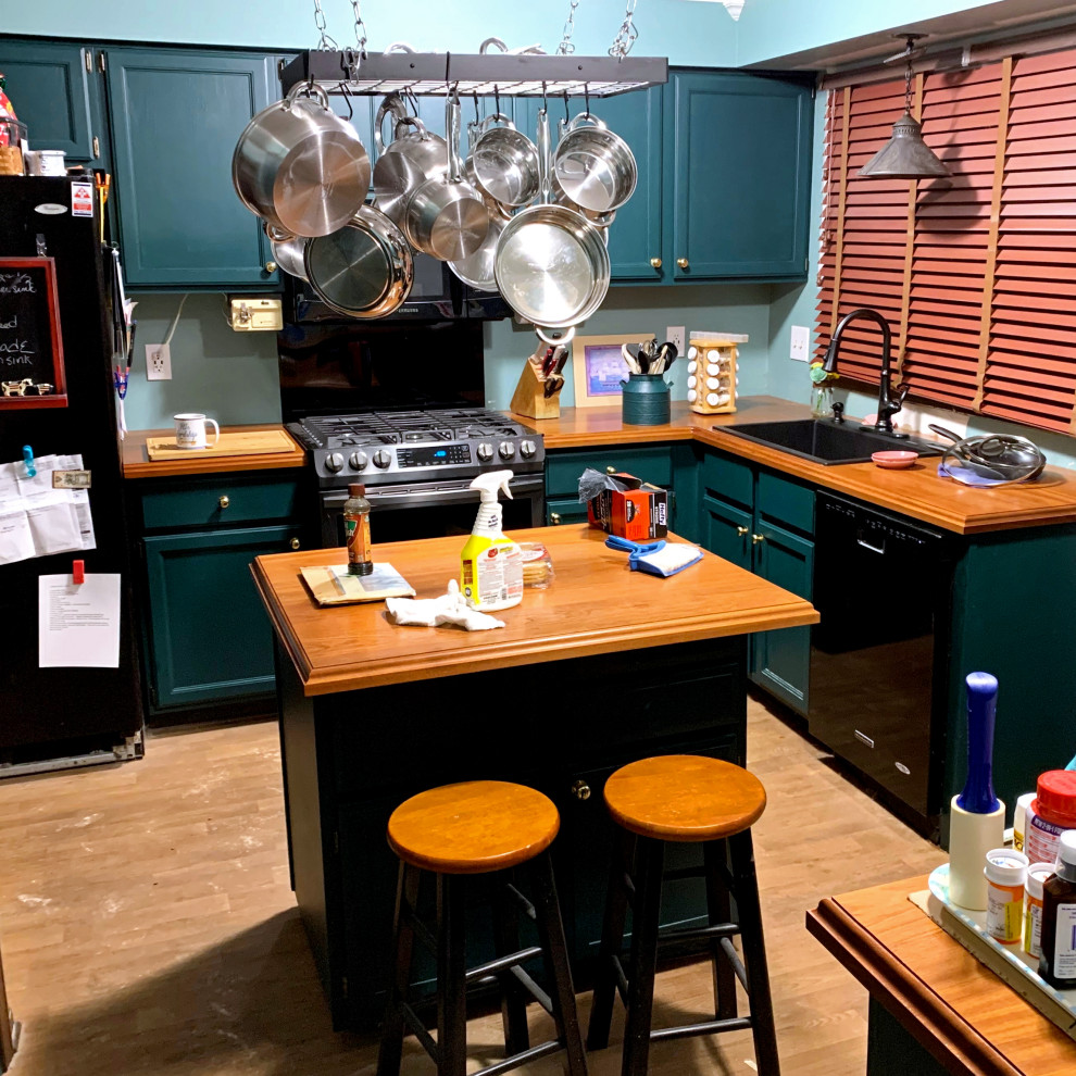 Example of a mid-sized classic u-shaped medium tone wood floor and brown floor enclosed kitchen design in Other with a drop-in sink, recessed-panel cabinets, wood countertops, black appliances, an island, red countertops, green cabinets and green backsplash