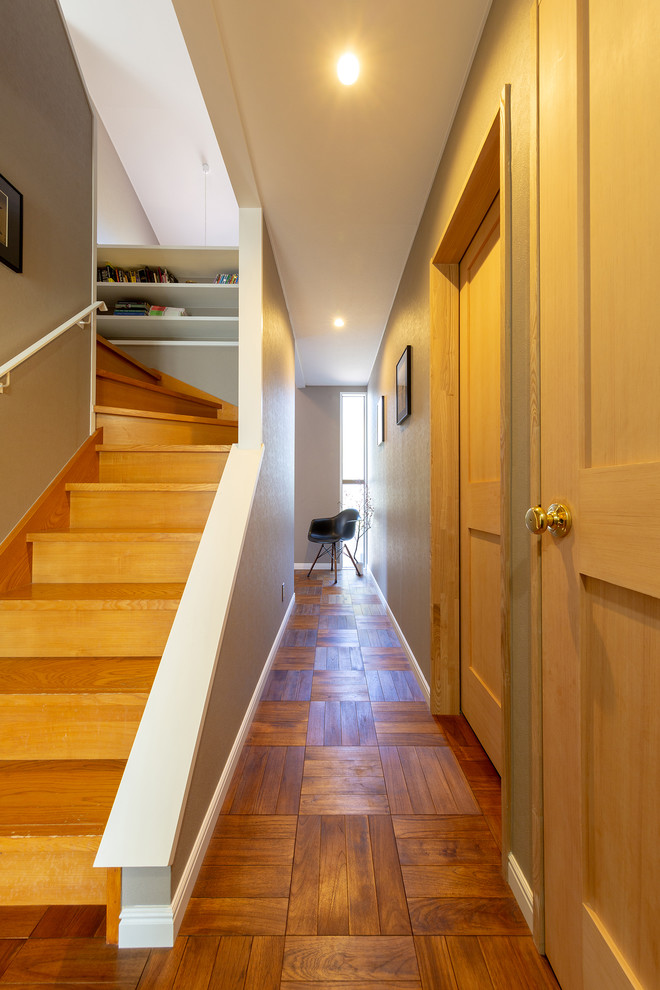 Midcentury hallway in Other with grey walls, medium hardwood floors and brown floor.