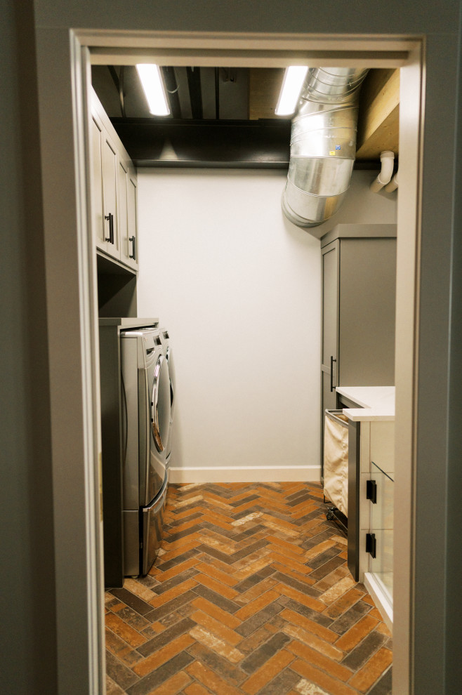 Photo of a medium sized modern galley utility room in Cedar Rapids with shaker cabinets, dark wood cabinets, a side by side washer and dryer, multi-coloured floors, white worktops, blue walls and marble worktops.