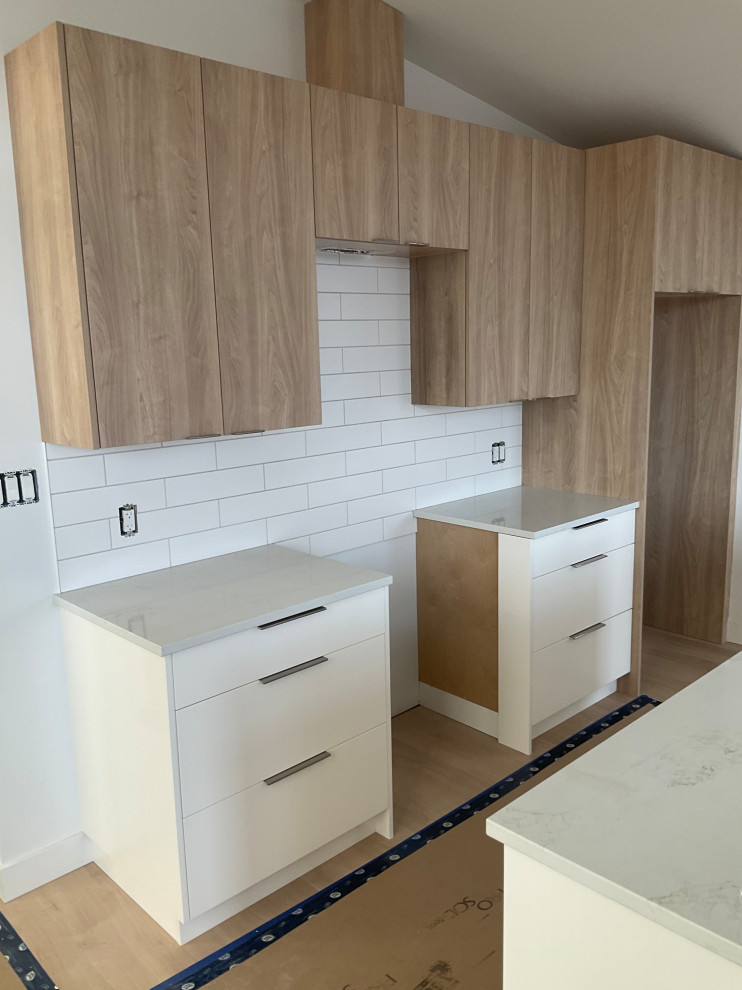 Contemporary kitchen with white cabinets, built-in appliances, and a wood island