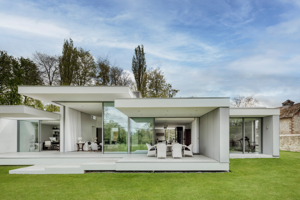This is an example of a large and white contemporary bungalow render detached house in Oxfordshire.