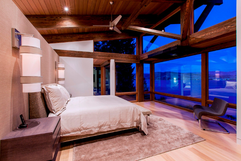 Large contemporary master bedroom in Other with white walls, light hardwood floors, no fireplace and brown floor.