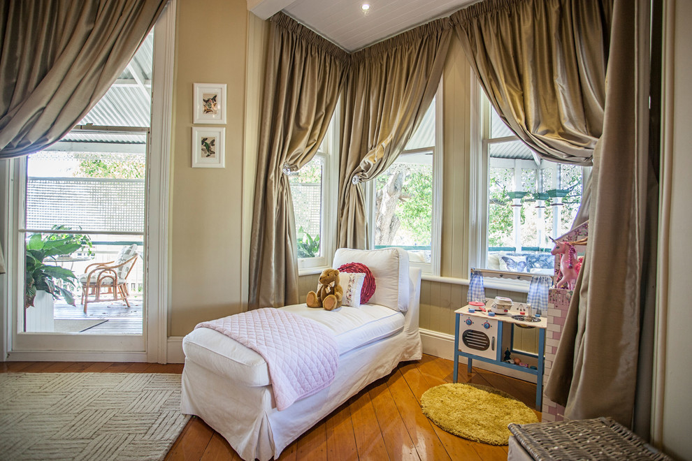 Photo of a mid-sized traditional kids' room for girls in Brisbane with beige walls and medium hardwood floors.