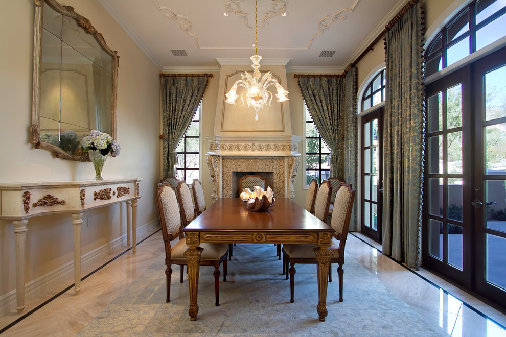This is an example of an expansive traditional separate dining room in Phoenix with beige walls, a standard fireplace and marble floors.