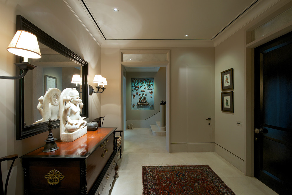 This is an example of a transitional hallway in Mumbai with beige walls and marble floors.