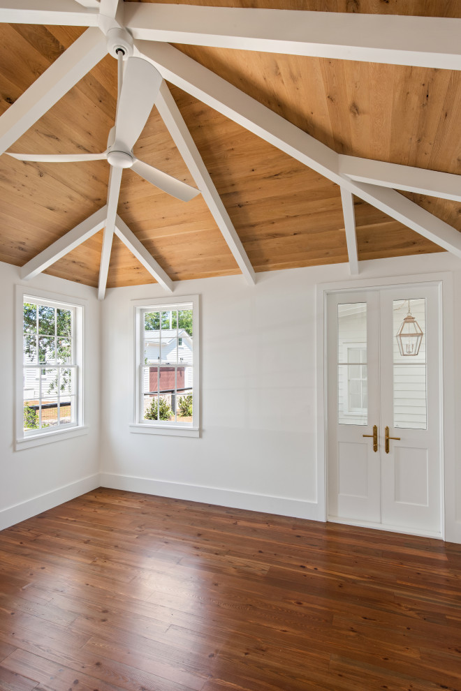 This is an example of a classic master bedroom in Charleston with white walls, medium hardwood flooring, a standard fireplace and a wood ceiling.