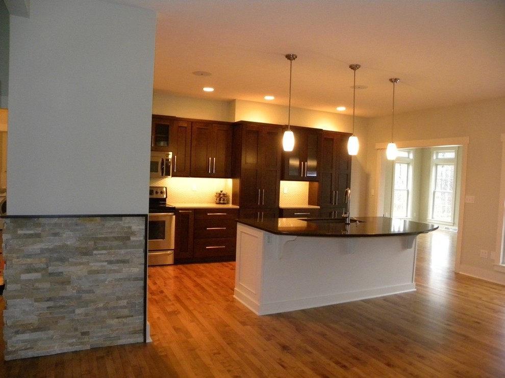 Kitchen - mid-sized u-shaped medium tone wood floor kitchen idea with an island