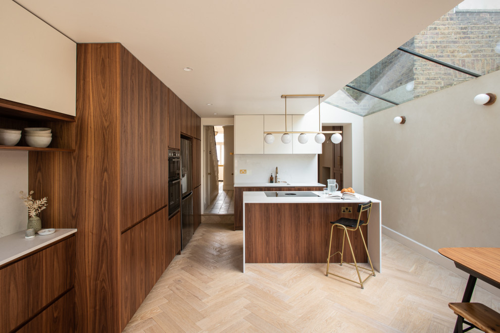 Esempio di una cucina moderna di medie dimensioni con lavello integrato, ante lisce, ante in legno bruno, top in superficie solida, paraspruzzi beige, elettrodomestici neri, parquet chiaro e top beige