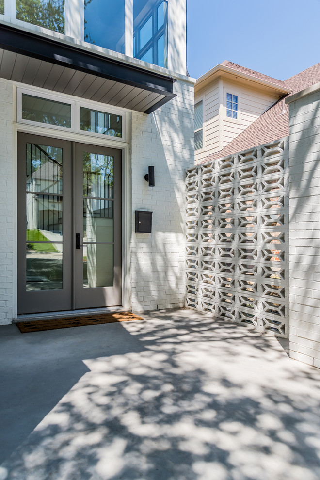 Example of a large transitional concrete floor home design design in Dallas with white walls and a white front door
