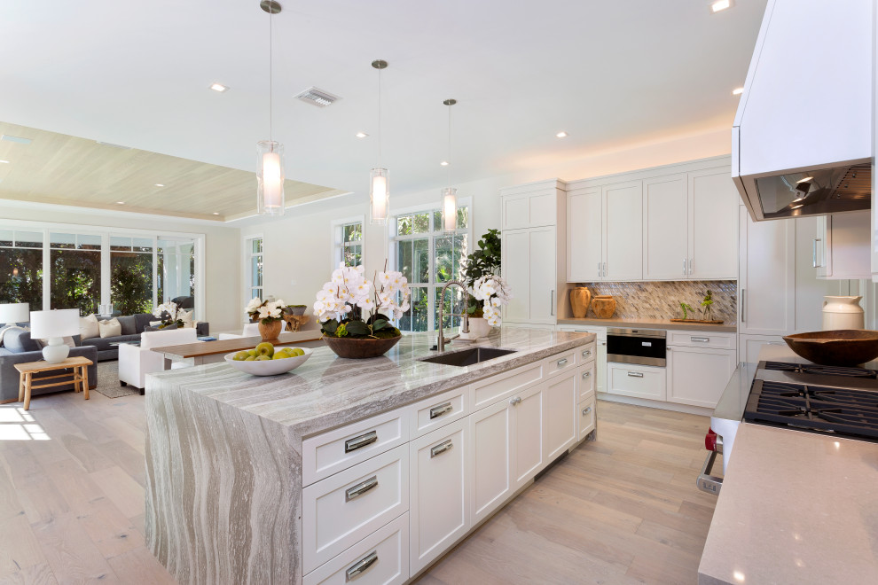 Inspiration for a large transitional l-shaped eat-in kitchen in Miami with an undermount sink, shaker cabinets, beige cabinets, grey splashback, panelled appliances, light hardwood floors, with island, beige floor and grey benchtop.