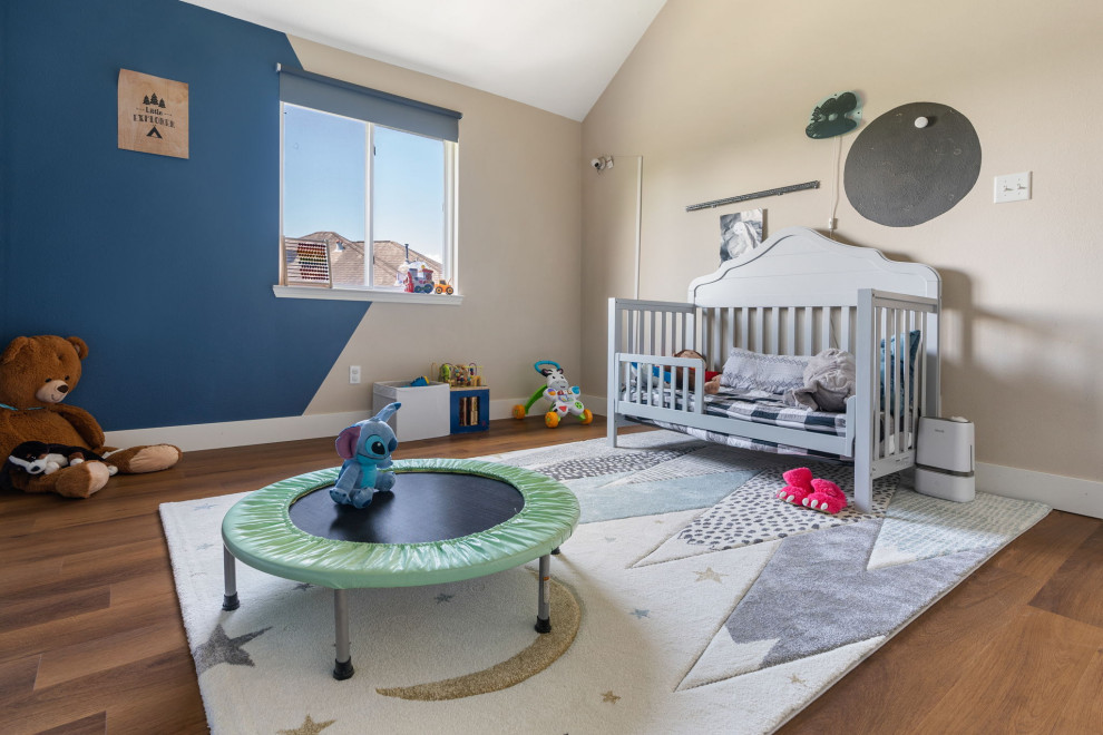 Idee per una cameretta per bambini da 4 a 10 anni stile americano di medie dimensioni con pareti blu, pavimento in vinile, pavimento marrone e soffitto a volta