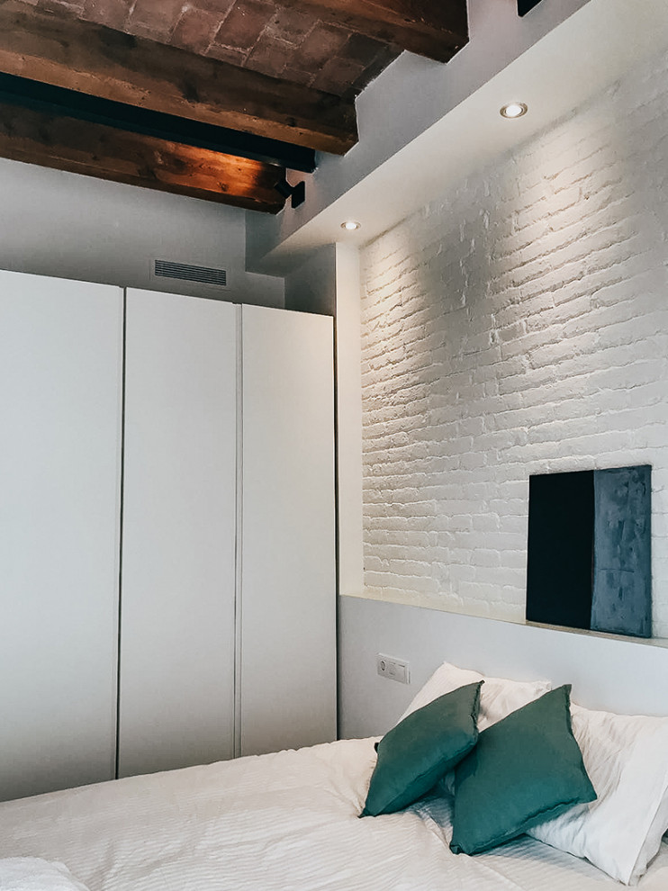 Foto de dormitorio principal urbano de tamaño medio con paredes blancas, suelo de baldosas de cerámica, suelo multicolor, vigas vistas y ladrillo