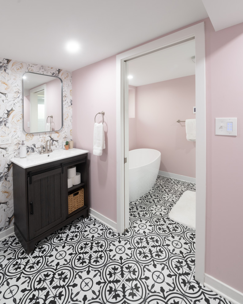 На фото: главный совмещенный санузел среднего размера с отдельно стоящей ванной, душем, унитазом-моноблоком, белой плиткой, плиткой кабанчик, розовыми стенами, полом из керамической плитки, столешницей из искусственного камня, разноцветным полом, открытым душем, белой столешницей, тумбой под одну раковину, напольной тумбой и обоями на стенах