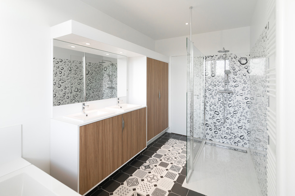 Photo of a mid-sized contemporary kids bathroom in Le Havre with beaded inset cabinets, light wood cabinets, a drop-in tub, a curbless shower, a two-piece toilet, white walls, cement tiles, an undermount sink, laminate benchtops, grey floor and an open shower.