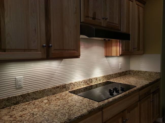 Inspiration for a transitional kitchen remodel with medium tone wood cabinets, granite countertops, white backsplash, ceramic backsplash, stainless steel appliances and yellow walls