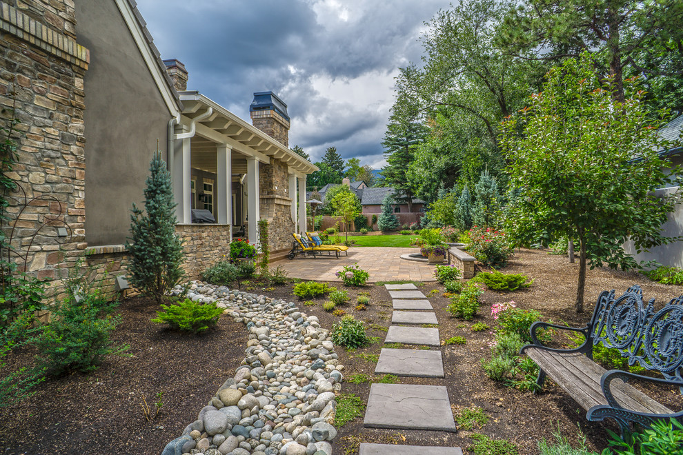 Photo of a large traditional side yard partial sun garden for spring in Denver with a garden path and concrete pavers.