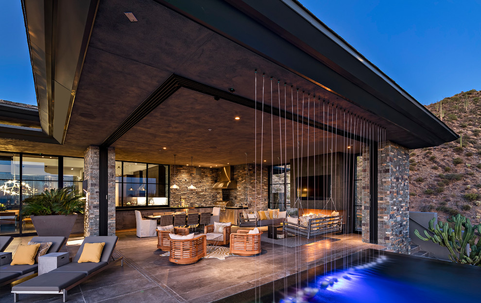Design ideas for an expansive contemporary backyard patio in Phoenix with natural stone pavers and a water feature.