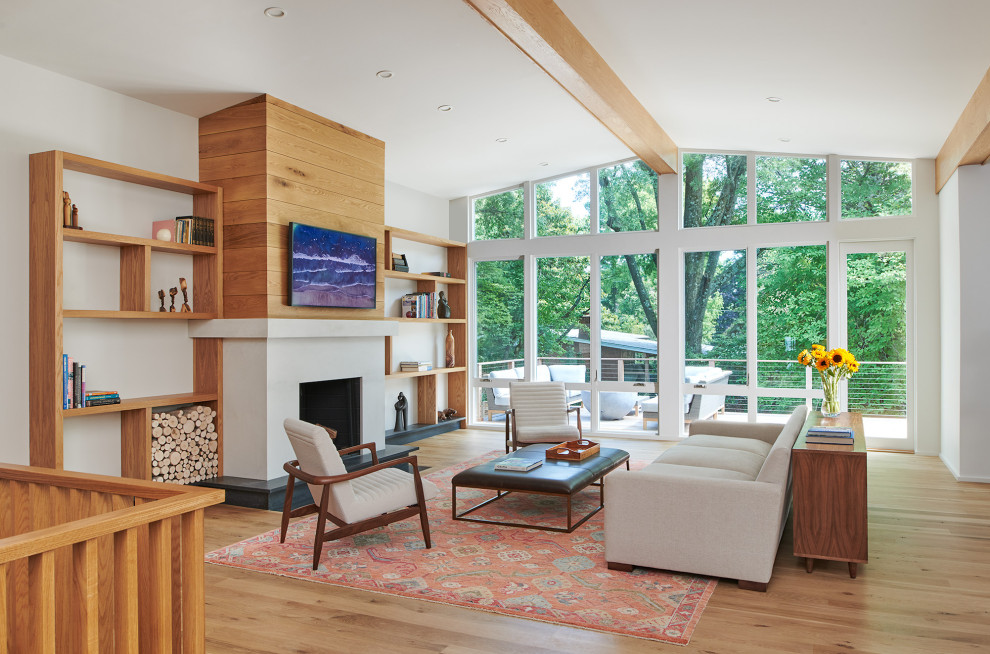 Inspiration for a mid-sized midcentury open concept family room in DC Metro with white walls, light hardwood floors, a standard fireplace, a stone fireplace surround, a built-in media wall and vaulted.