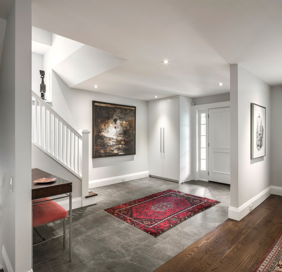 Large transitional porcelain tile and gray floor foyer photo in Toronto with white walls and a white front door