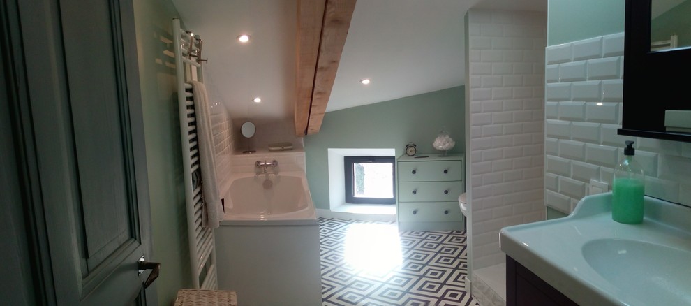 This is an example of a small midcentury bathroom in Grenoble with a curbless shower, a wall-mount toilet, white tile, subway tile, green walls, linoleum floors, a console sink and white floor.