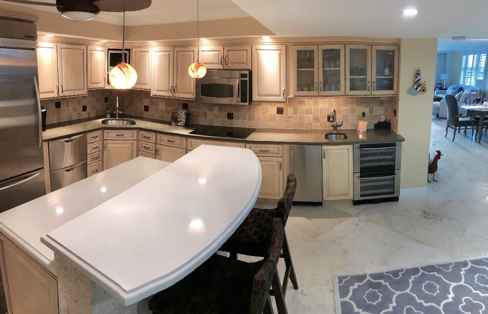 Inspiration for a mid-sized transitional l-shaped eat-in kitchen in Other with an undermount sink, raised-panel cabinets, beige cabinets, quartz benchtops, beige splashback, travertine splashback, stainless steel appliances, travertine floors, with island and beige floor.
