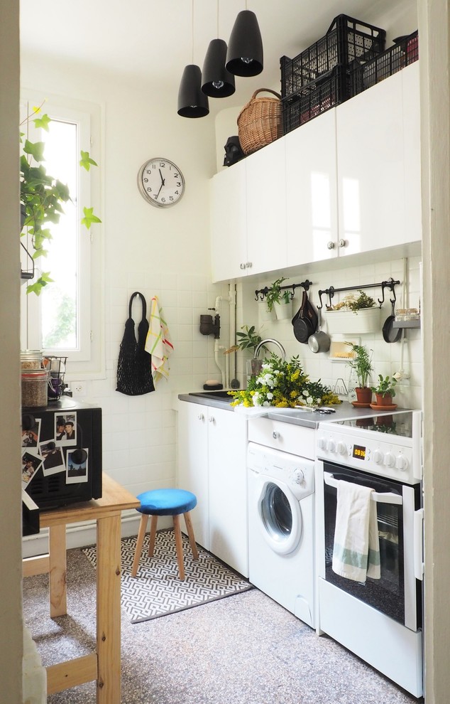 Design ideas for a small contemporary single-wall kitchen in Paris with white cabinets, white splashback, terrazzo floors, grey floor, grey benchtop, a drop-in sink, flat-panel cabinets and white appliances.