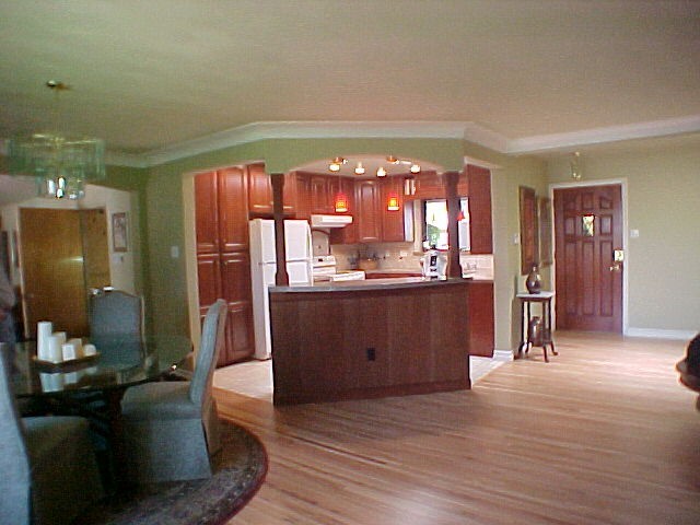Example of a mid-sized u-shaped ceramic tile kitchen design in Albuquerque with an undermount sink, raised-panel cabinets, dark wood cabinets, quartz countertops, beige backsplash, ceramic backsplash, white appliances and an island
