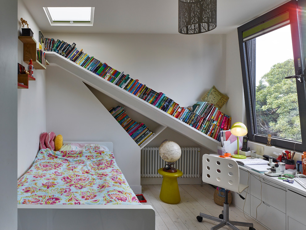 This is an example of a mid-sized contemporary gender-neutral kids' bedroom for kids 4-10 years old in London with white walls and light hardwood floors.