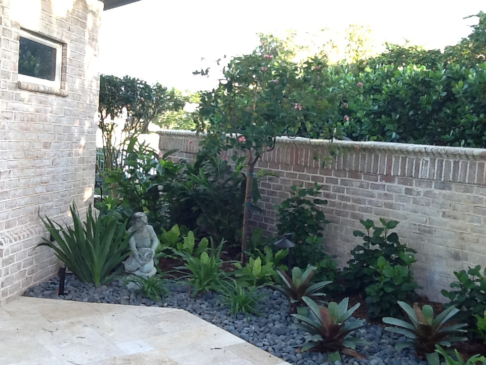 This is an example of a large courtyard partial sun formal garden for summer in Miami with gravel.