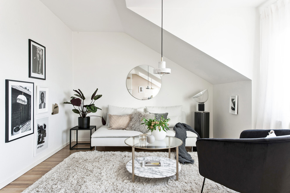 This is an example of a small scandinavian formal loft-style living room in Gothenburg with white walls, light hardwood floors and beige floor.