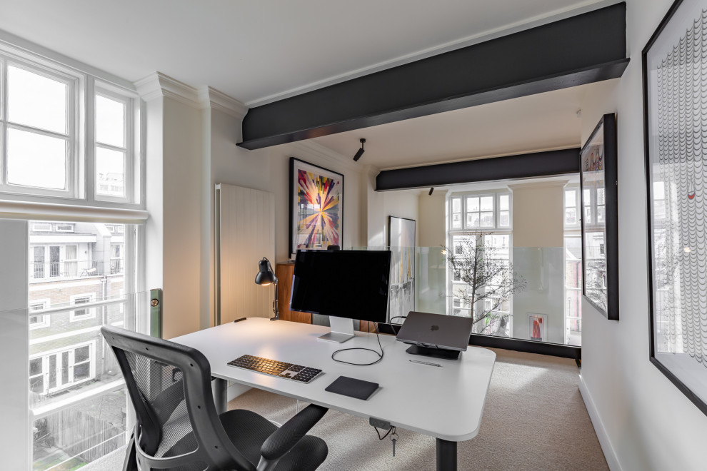 Modernes Arbeitszimmer mit beiger Wandfarbe, Teppichboden, beigem Boden und freigelegten Dachbalken in London