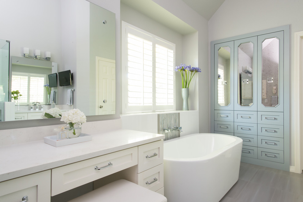 Inspiration for a mid-sized contemporary master bathroom in Dallas with a drop-in sink, flat-panel cabinets, yellow cabinets, engineered quartz benchtops, a freestanding tub, a corner shower, a one-piece toilet, gray tile, glass tile, grey walls and porcelain floors.