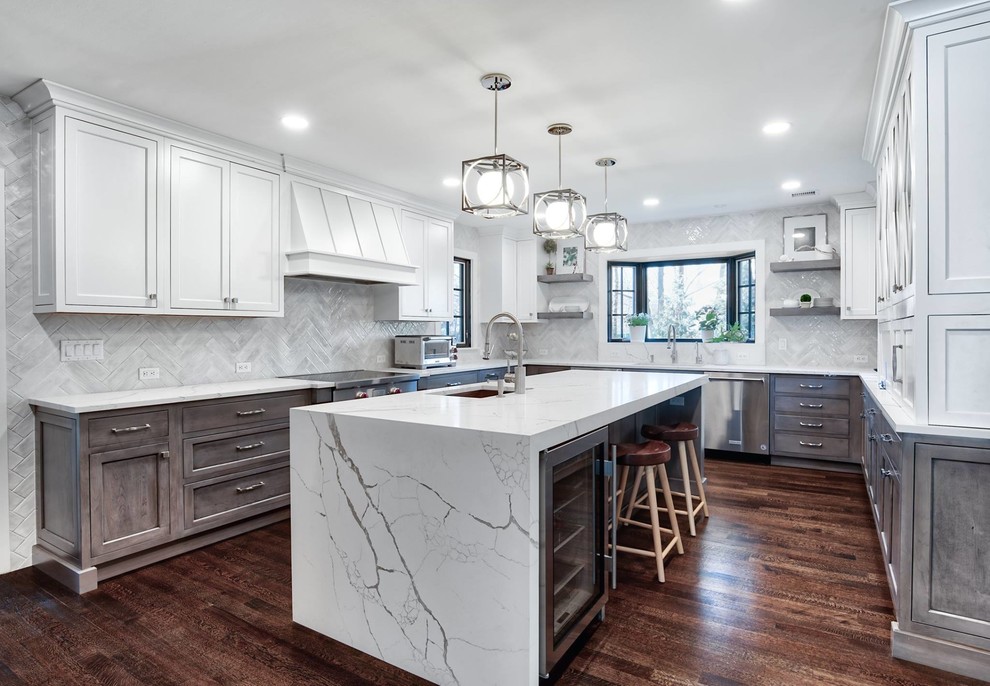 Inspiration for a large transitional u-shaped brown floor and dark wood floor kitchen remodel in New York with an undermount sink, ceramic backsplash, stainless steel appliances, an island, white countertops, shaker cabinets, white cabinets and gray backsplash