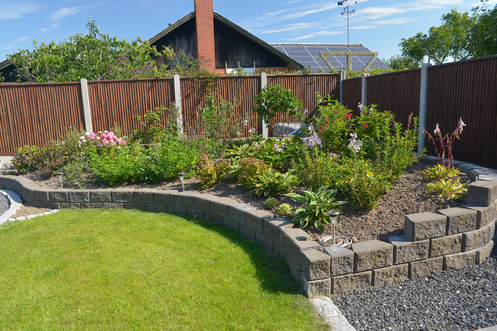 Mid-sized contemporary backyard full sun formal garden in Esbjerg with a container garden and natural stone pavers for summer.