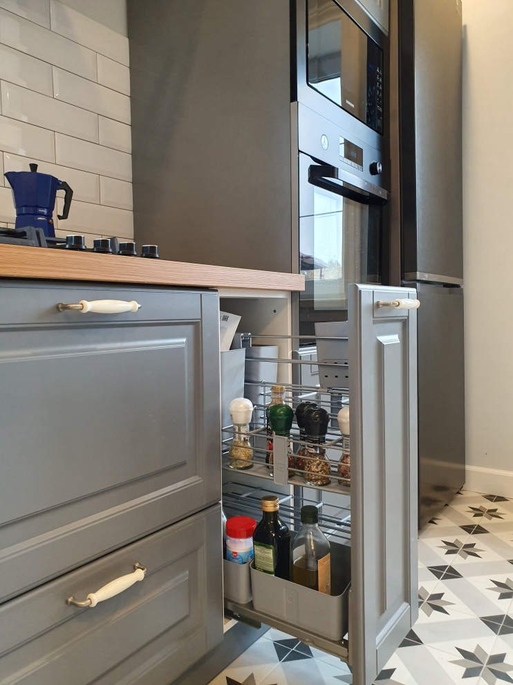 Inspiration for a medium sized traditional single-wall kitchen/diner in Moscow with raised-panel cabinets, grey cabinets, laminate countertops, white splashback, metro tiled splashback, ceramic flooring, a breakfast bar, white floors and brown worktops.