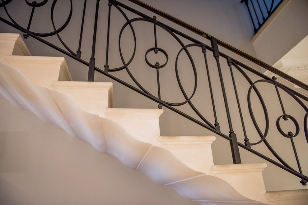 This is an example of a traditional limestone u-shaped staircase in Other with limestone risers.