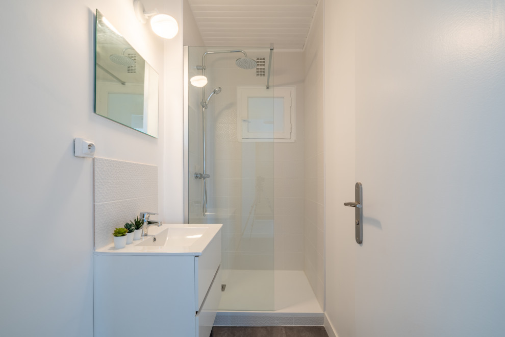Пример оригинального дизайна: главная, серо-белая ванная комната среднего размера в современном стиле с фасадами с декоративным кантом, белыми фасадами, душем без бортиков, раздельным унитазом, белой плиткой, керамической плиткой, белыми стенами, полом из ламината, врезной раковиной, столешницей из плитки, серым полом, душем с распашными дверями, белой столешницей, окном, тумбой под одну раковину, подвесной тумбой и потолком из вагонки