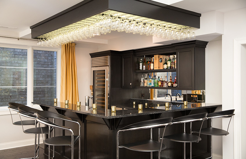 Mid-sized modern l-shaped seated home bar in Chicago with an undermount sink, shaker cabinets, black cabinets, granite benchtops, multi-coloured splashback, mirror splashback and dark hardwood floors.