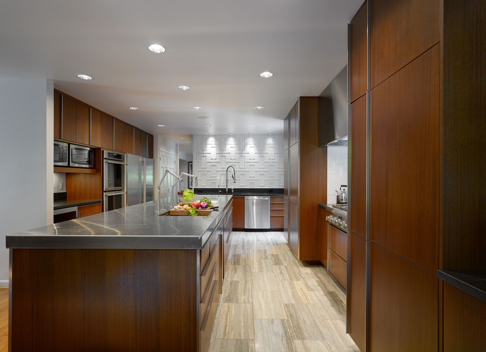 Photo of a modern eat-in kitchen in Cincinnati with ceramic splashback, stainless steel benchtops, flat-panel cabinets, dark wood cabinets, white splashback, stainless steel appliances and an undermount sink.