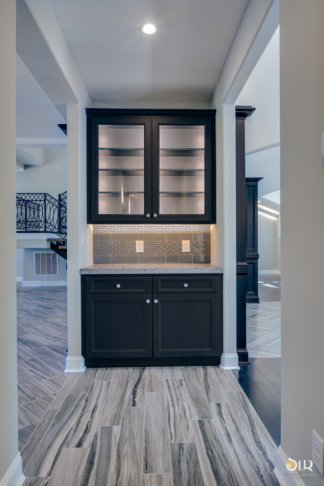 Photo of a transitional single-wall home bar in Other with shaker cabinets, dark wood cabinets, quartzite benchtops, light hardwood floors and beige floor.