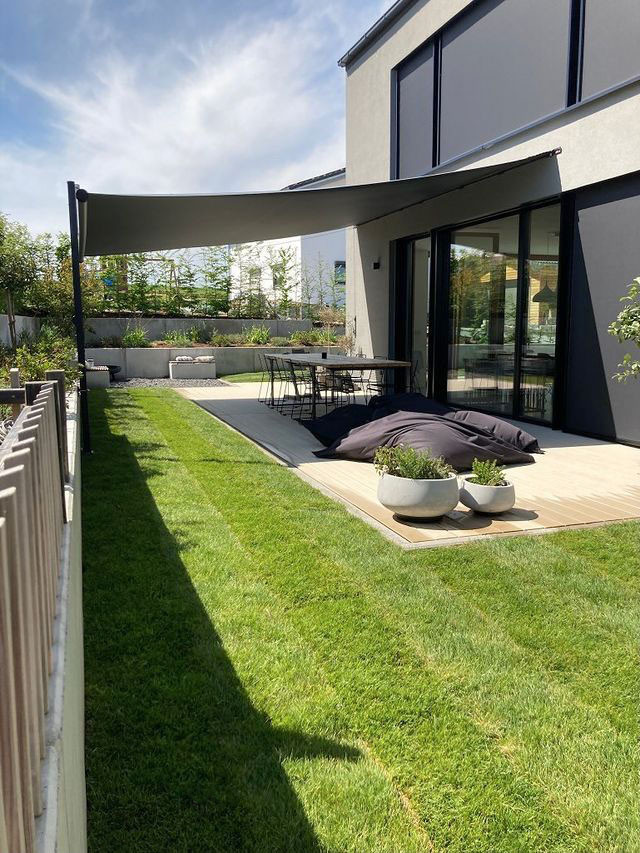 Ejemplo de terraza planta baja contemporánea grande en patio lateral con toldo