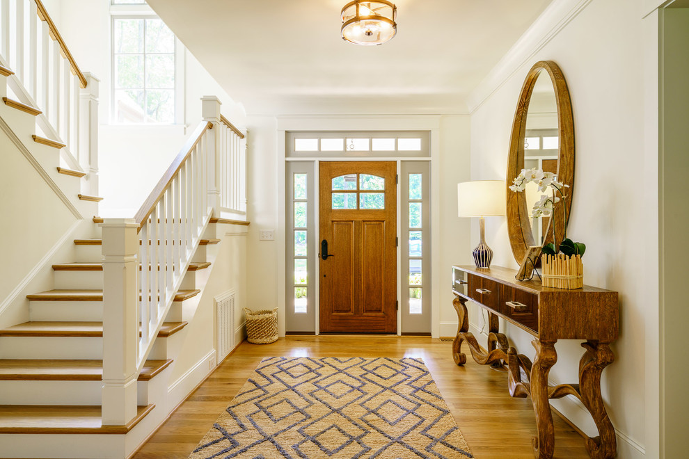 Photo of a mid-sized transitional front door in Other with white walls, medium hardwood floors, a single front door, a medium wood front door and brown floor.