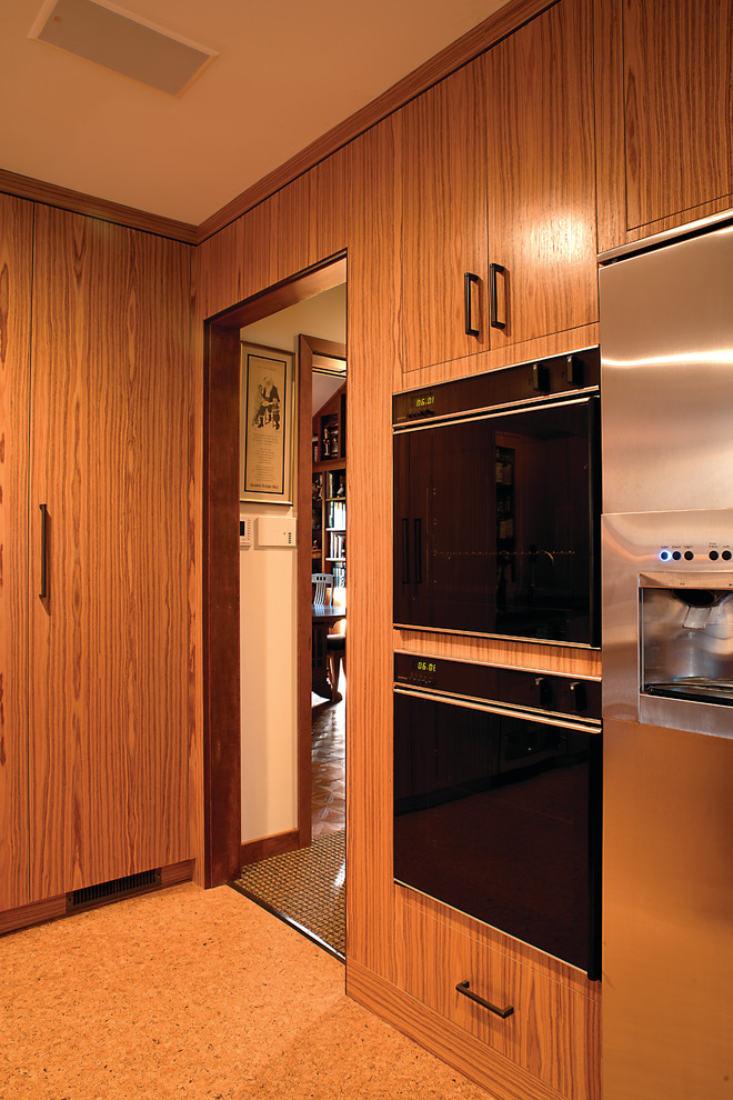 This is an example of a large contemporary galley eat-in kitchen in Philadelphia with a single-bowl sink, flat-panel cabinets, medium wood cabinets, granite benchtops, beige splashback, ceramic splashback, stainless steel appliances, cork floors and with island.