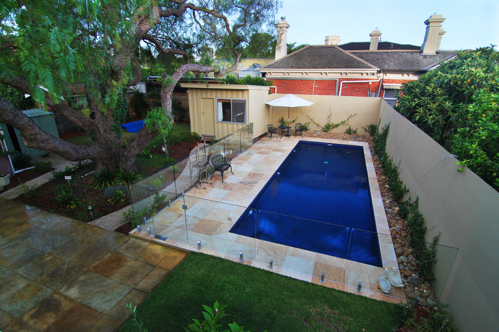 Inspiration for a mid-sized traditional backyard rectangular pool in Melbourne with natural stone pavers.