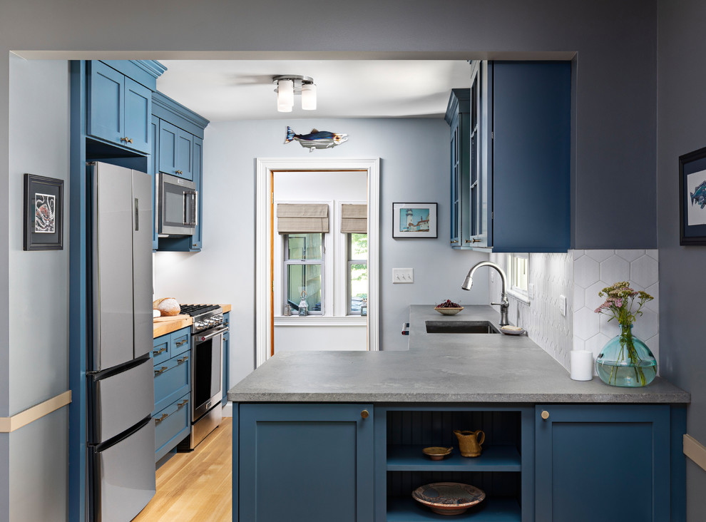 Inspiration for a small beach style galley eat-in kitchen in Detroit with an undermount sink, shaker cabinets, blue cabinets, quartz benchtops, grey splashback, porcelain splashback, stainless steel appliances, light hardwood floors, no island, brown floor and grey benchtop.