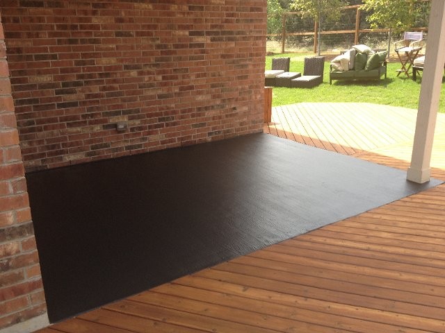 Example of a mid-sized transitional backyard deck design in Austin with a roof extension