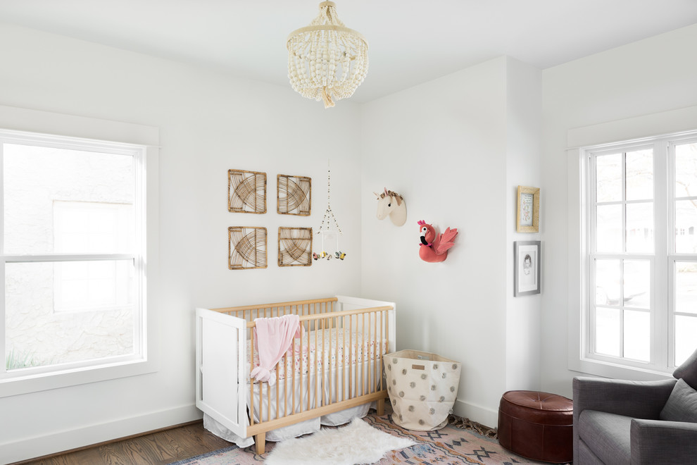 Inspiration for a mid-sized arts and crafts nursery for girls in Birmingham with white walls, medium hardwood floors and brown floor.